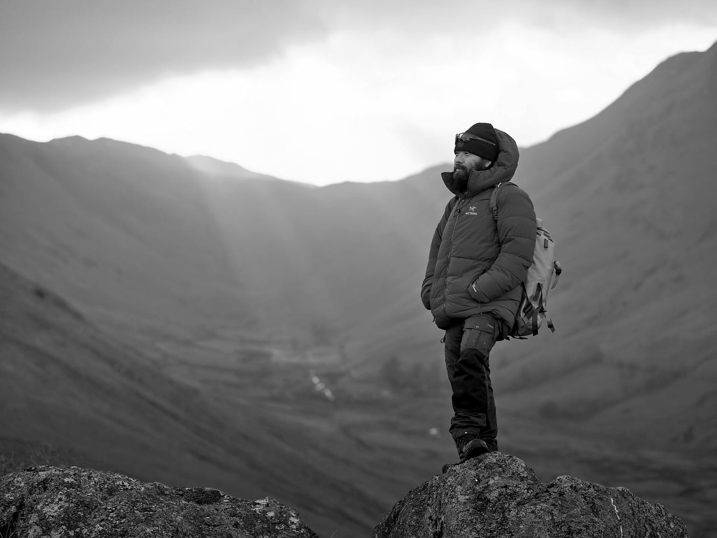 Krishna Thapa standing on a rock above a valley in low morning light